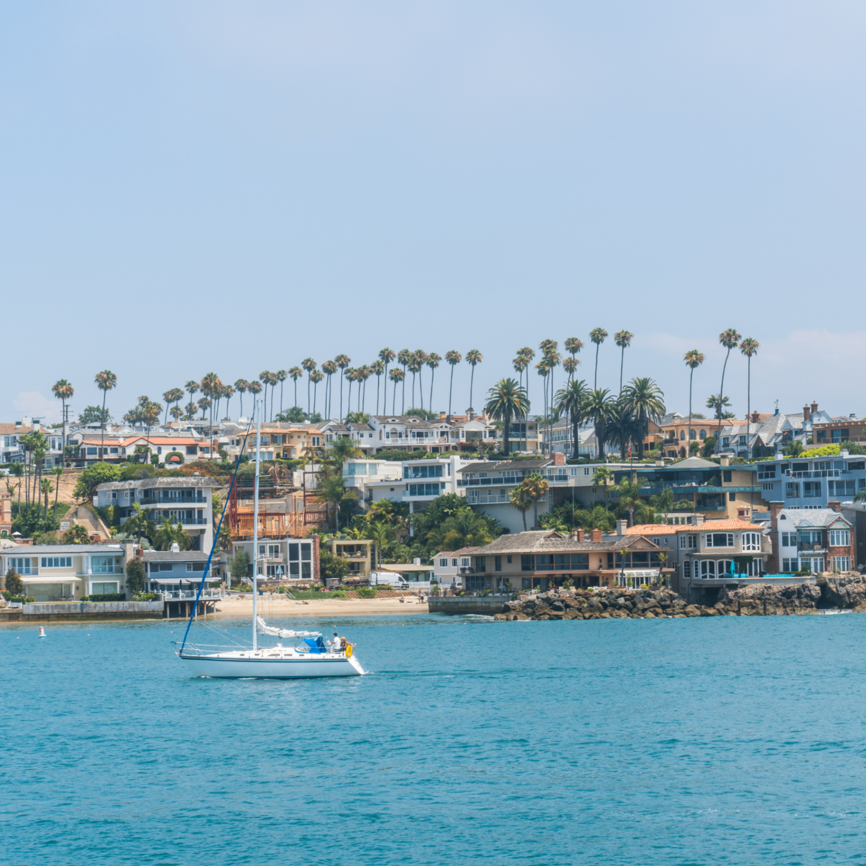 Newport Beach coastal homes with sailboat